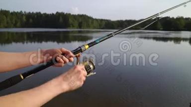 女双手握鱼竿，扭住线圈.. 渔夫拿着一根纺棒，在河、湖、池塘里钓鱼